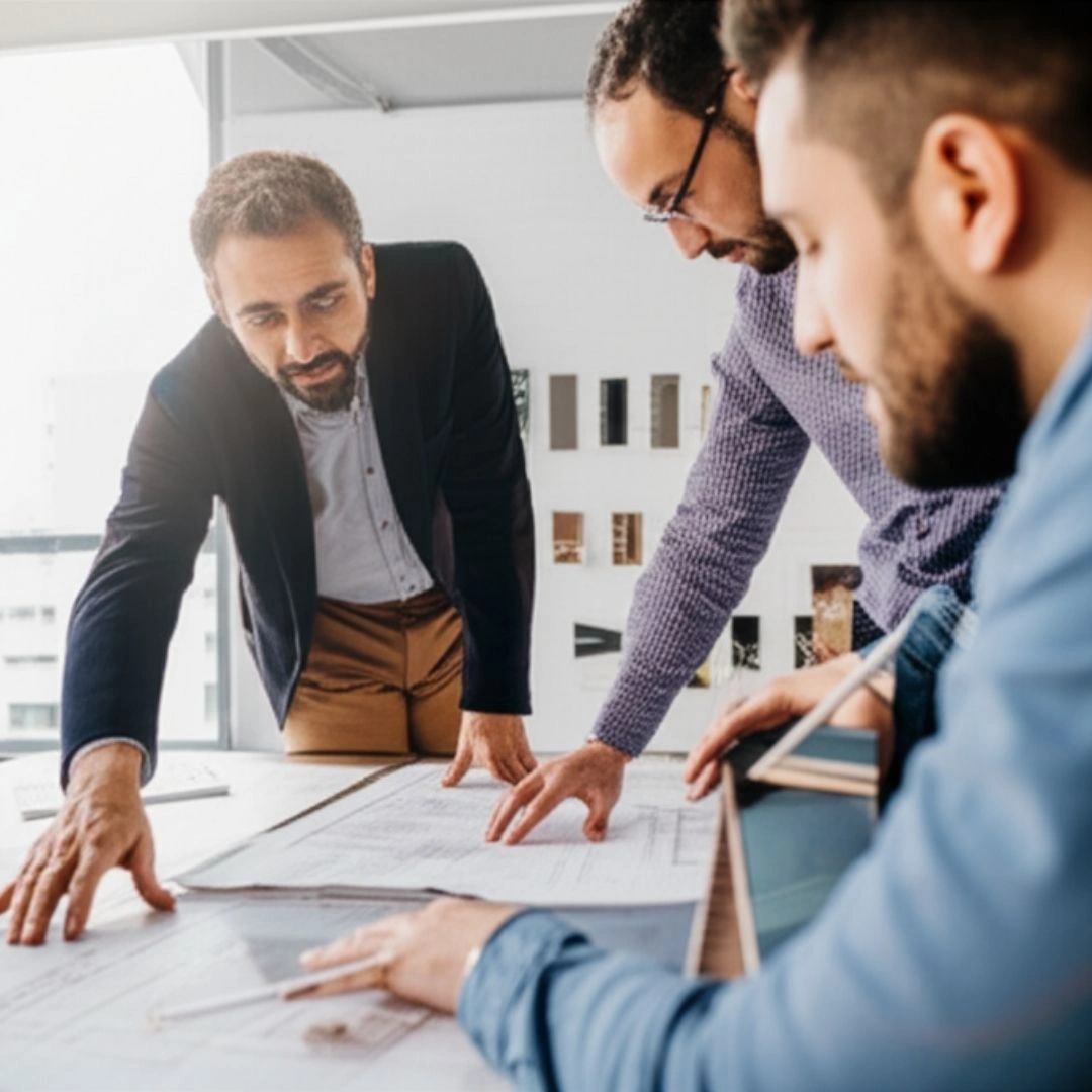 Professionnels d'Art Sun collaborant sur des plans architecturaux, illustrant un partenariat innovant.